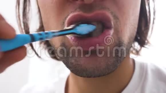 在白色背景下用牙刷将男性的面部特写刷牙早上的治疗视频的预览图