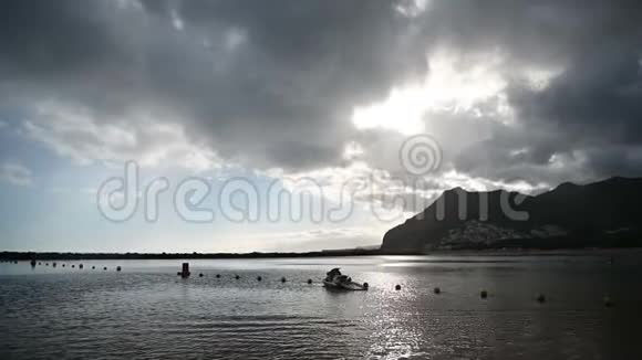 多云天气有山地背景的特内里夫海滩雨视频的预览图
