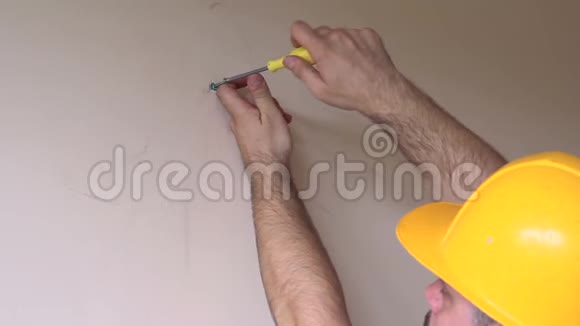 建筑工人和杂工从事公寓改造工作用黄色螺丝刀螺丝钢螺丝从墙上拧出视频的预览图