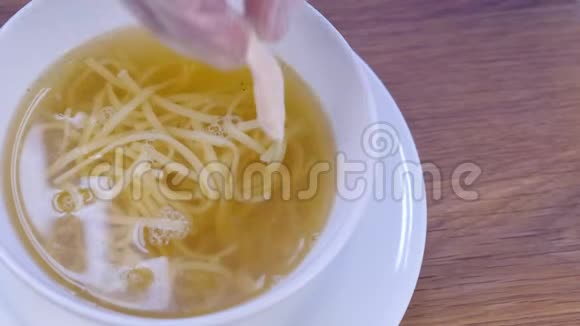 厨师把鸡汤和面条放在白碗里放鸡块双手特写视频的预览图