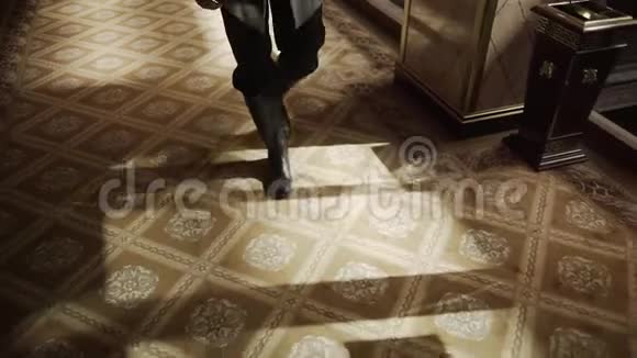 穿着棕色运动鞋的人的双腿走在家里长长的走廊上的蓝色地毯上把人的双脚踩得很紧视频的预览图