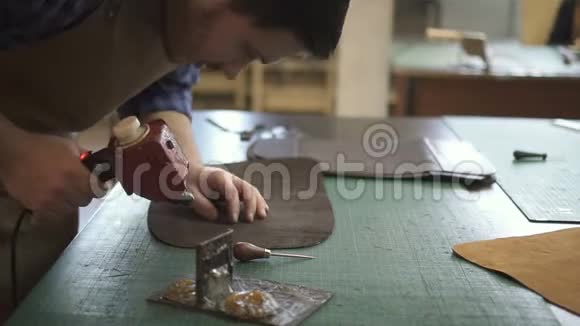 男鞋匠将胶水涂在工作室的黑色细节和紧固件上的肖像视频的预览图