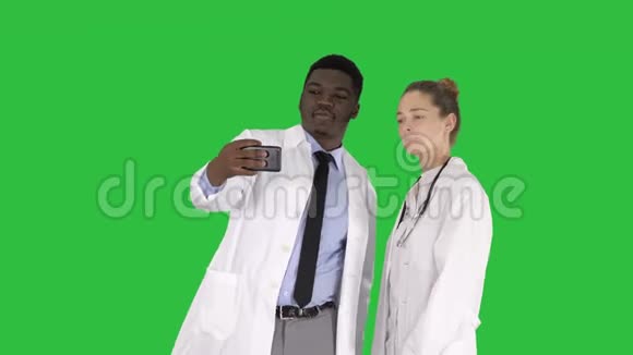 两位医生正在使用智能手机自拍并在绿色屏幕上微笑Chroma键视频的预览图