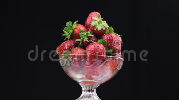 旋转一堆红色草莓躺在玻璃花瓶里视频的预览图
