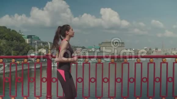中国运动女性沿着河桥慢跑视频的预览图
