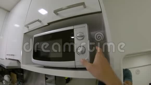 一名男子在厨房用微波炉拍摄的视角视频的预览图
