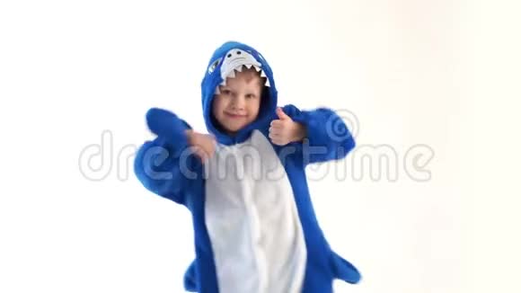 快乐的小男孩穿着睡衣在白色背景上跳舞穿着蓝鲨服装视频的预览图