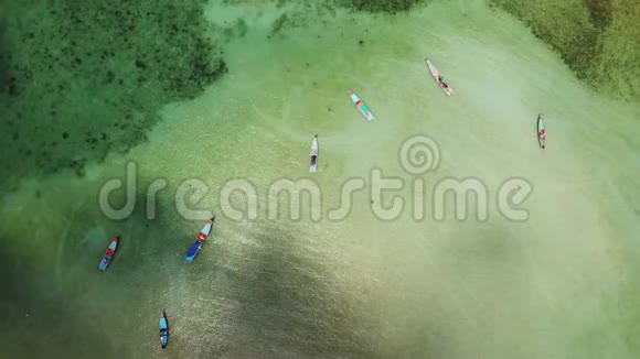 小彩色的木制渔船漂浮在蔚蓝的水面上覆盖着海洋海岸上的珊瑚热带视频的预览图