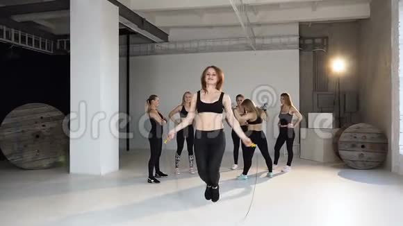 运动员女孩在健身房里用跳绳跳跃年轻的跳绳女子在健身房锻炼是运动和视频的预览图