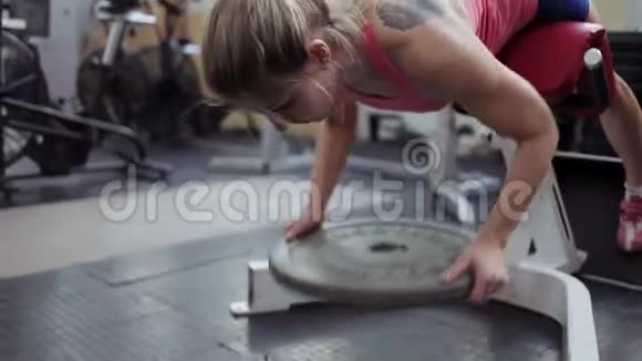 年轻的女运动员在背部肌肉上工作带重量的超伸视频的预览图