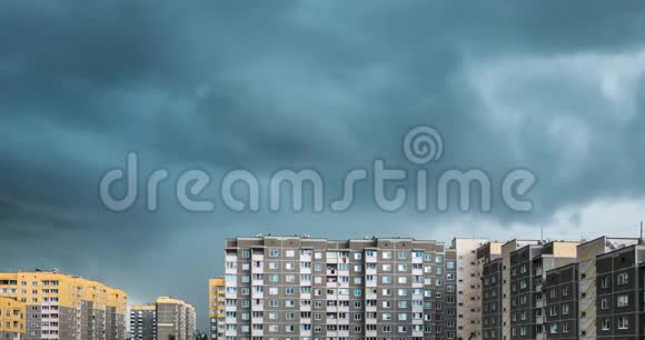 黄色多层公寓楼背景下暴风雨前白色蓬松翻滚的云层的时间流逝片段视频的预览图