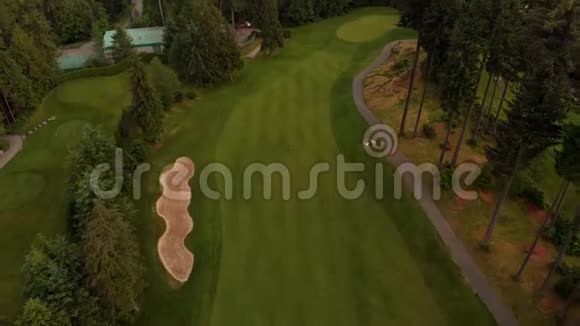 一架飞机从坐落在森林中的高尔夫球场球道上飞过从背景中看到了BurrardInlet视频的预览图
