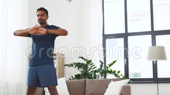 有健身追踪器的男人在家伸腰视频的预览图