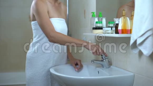 可爱的女士在镜子前洗脸参观化妆师后满意视频的预览图