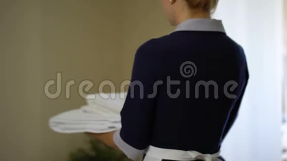 微笑的女佣用干净的雪白毛巾转身预订酒店房间视频的预览图