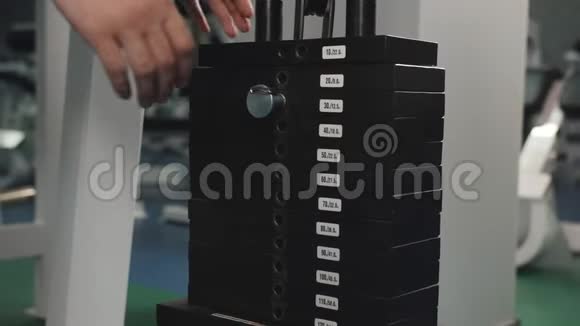 人的特写在健身房更换重量板重重机以增加负荷视频的预览图