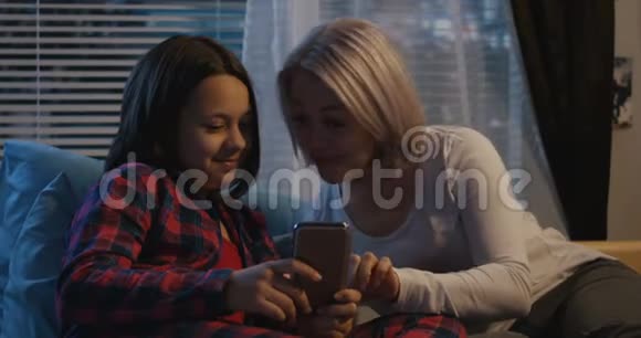 母亲和女儿使用智能手机视频的预览图