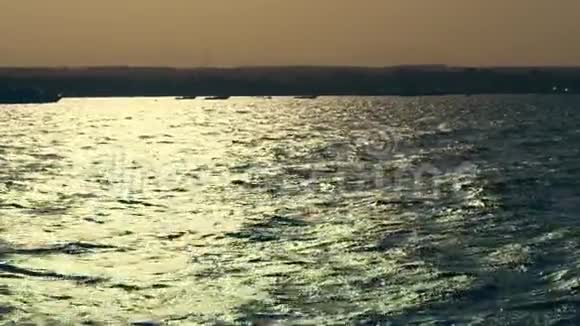 夏季海景日落时的海浪在柔和的阳光下在水上眩光海湾海上游艇你视频的预览图