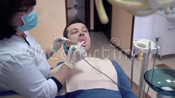 特写女牙医用口内照相机检查病人的牙齿牙科疾病的治疗和预防视频的预览图