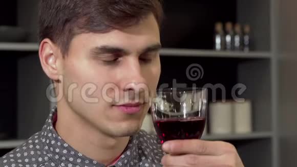帅哥闻着美味的红酒在家放松视频的预览图
