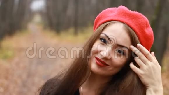 戴着红色贝雷帽的女人嘴唇发烫看着室外的摄像机视频的预览图