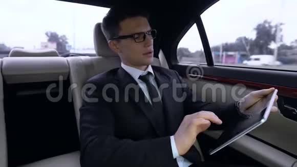 体贴的经理在平板电脑上工作乘豪华车利用交通时间视频的预览图