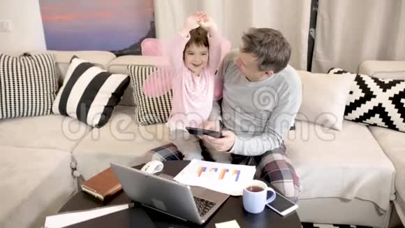忙碌的父亲和女儿坐在他的大腿上视频的预览图