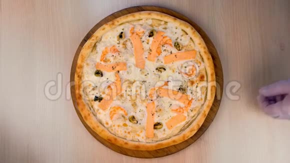 烹饪切比萨饼与海鲜和奶酪切片在木板上特写视频的预览图