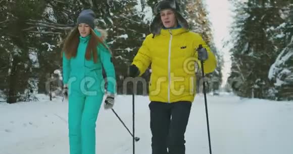 爱的男人和女人在树林里慢动作滑雪互相看着对方微笑情人节视频的预览图