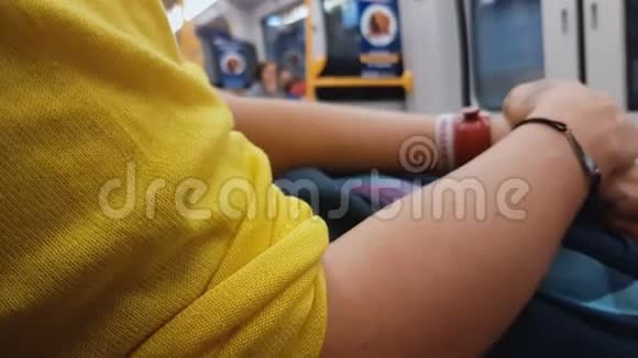 穿黄色衬衫的女性坐在城市火车上回家都市生活方式视频的预览图