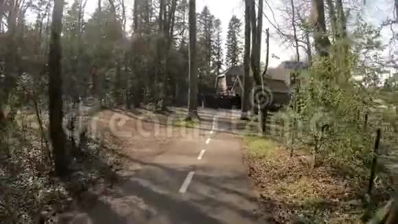 荷兰阳光明媚的一天骑自行车穿越森林的第一人称景观视频的预览图