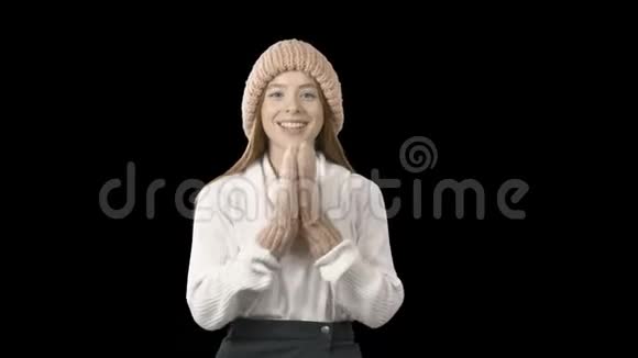 美丽的红发年轻女士戴着一顶针织的粉红色帽子和手套她玩得很佩服她的双手积极向上视频的预览图