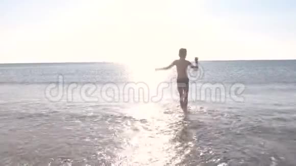 日落时男孩正在海边散步在海里游泳视频的预览图