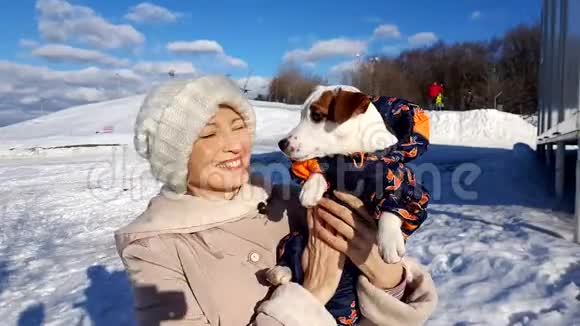 成年妇女抱着她的小狗在户外视频的预览图