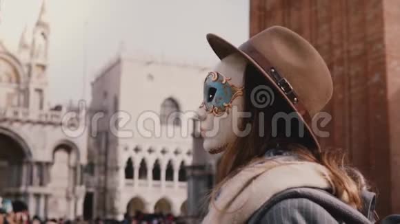 匿名女子长发回望镜头戴狂欢面具在威尼斯圣马可城广场慢动作视频的预览图