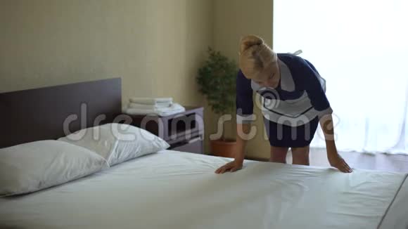漂亮的女服务员擦床单对新的看台动作很满意视频的预览图