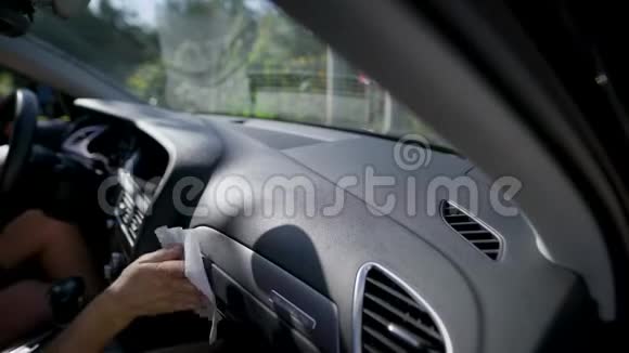 男人用餐巾擦车对优质车内饰板进行护理和清洁内部视频的预览图