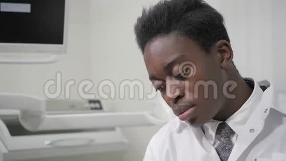 在平板电脑上的文件里年轻的非裔美国男性牙医在牙科办公室医学卫生视频的预览图