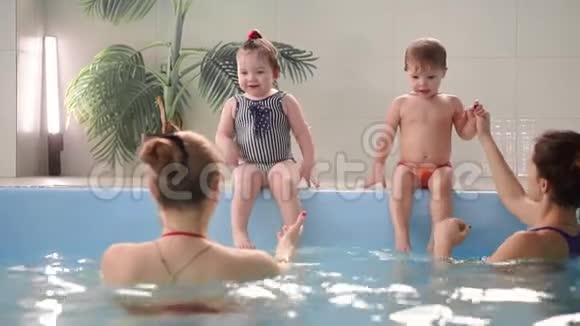 两个婴儿在水池里笑跳到水里拍手视频的预览图