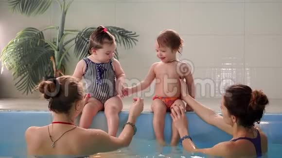 两个婴儿在水池里笑跳到水里拍手视频的预览图