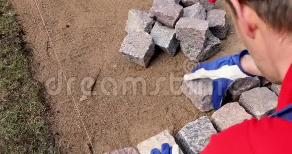 卵石铺砌工人安装花岗岩石铺视频的预览图