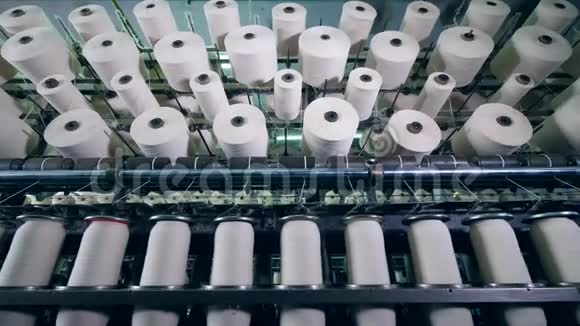 在一家工业纺织厂的现代机器上用纤维线轴切割视频的预览图