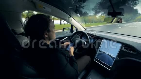 一辆自动汽车正沿着马路行驶司机坐在里面视频的预览图