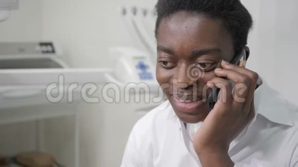 年轻的非裔美国男性牙医在牙科办公室在电话里和病人说话医学卫生视频的预览图