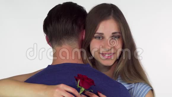 美丽的女人微笑着抱着红玫瑰拥抱她的男朋友视频的预览图