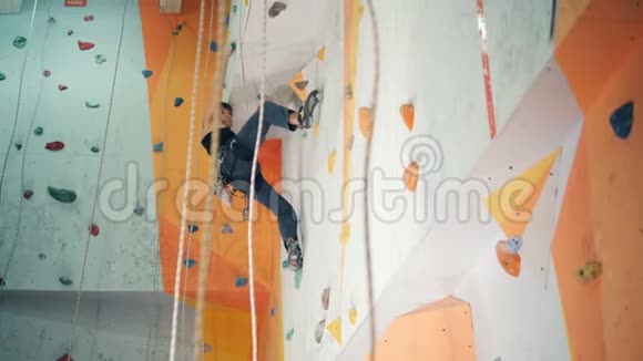 一个人爬上一个特殊的墙在一个中心底部的视图视频的预览图