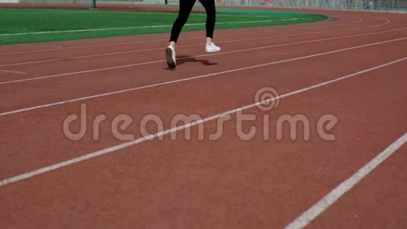 女子慢跑在体育场跑道上视频的预览图