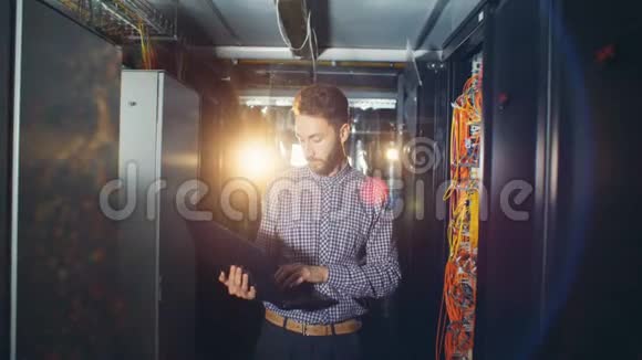 一个男人在服务器机房工作拿着笔记本电脑关门视频的预览图