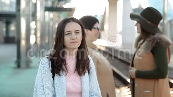 那个女人在火车站的车站等着坐火车人们的背景视频的预览图