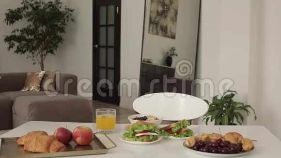 美丽的年轻女子坐在桌子上吃着美味可口的中档早餐视频的预览图